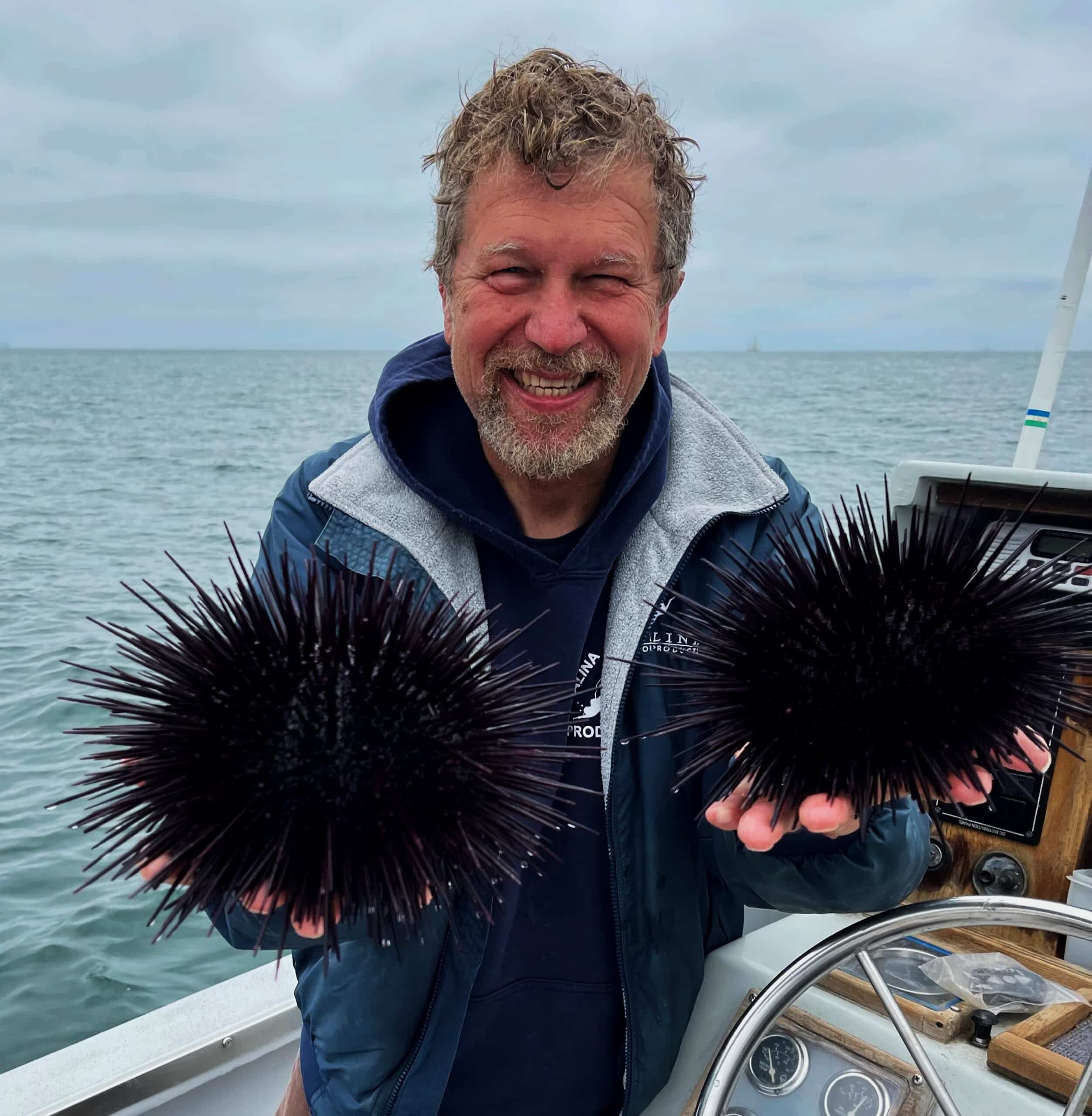 Dave Rudie, founder of Catalina Offshore Products Inc, holding a pair of sea urchins